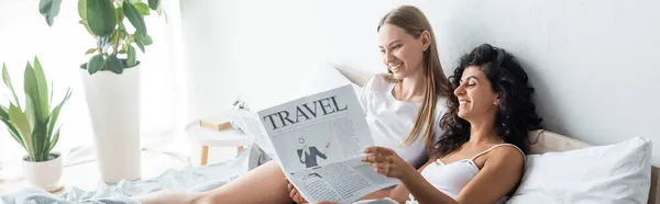 Felice coppia lesbica lettura giornale di viaggio in camera da letto, banner — Foto stock