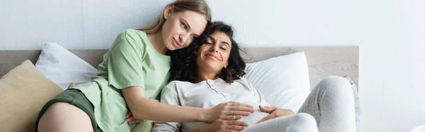 Donna felice toccare pancia di gioiosa fidanzata incinta in camera da letto, banner — Foto stock