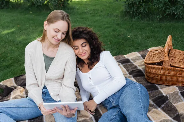 Felice lesbiche donne guardando tablet digitale durante il picnic — Foto stock