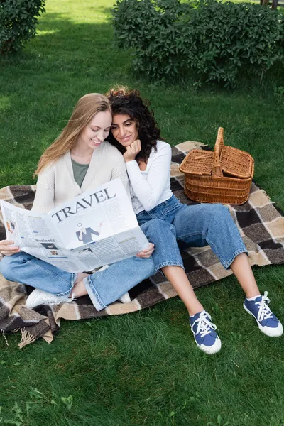 High angle view of happy lesbian couple reading travel newspaper in park — Stock Photo