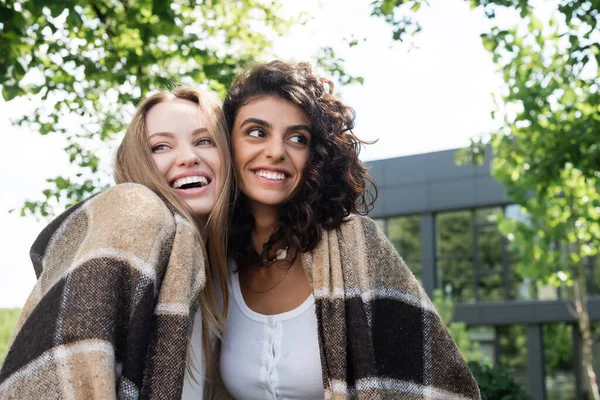 Glückliches lesbisches Paar in Decke gehüllt, draußen lachend — Stockfoto