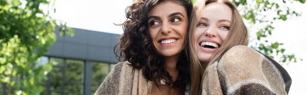 Heureux couple lesbien couvert de couverture riant dans le parc, bannière — Photo de stock