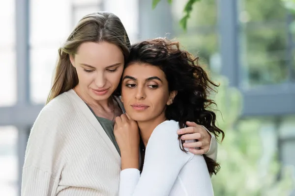 Woman hugging curly young girlfriend outside — Stock Photo