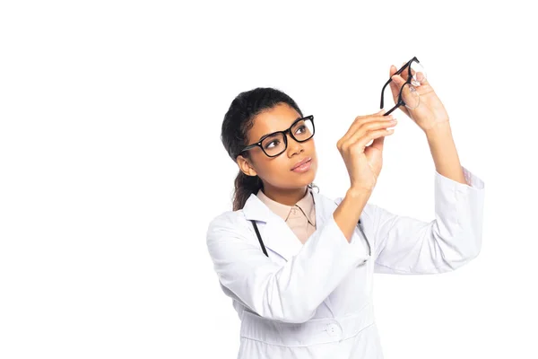 Joven afroamericano oculista sosteniendo gafas aisladas en blanco - foto de stock