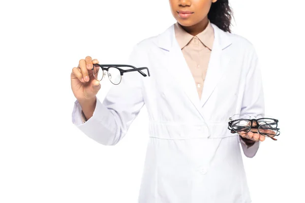 Cropped view of african american doctor holding eyeglasses in hands isolated on white — Stock Photo