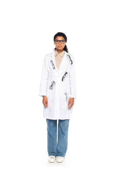 Full length of young african american oculist in eyeglasses on coat on white background — Stock Photo