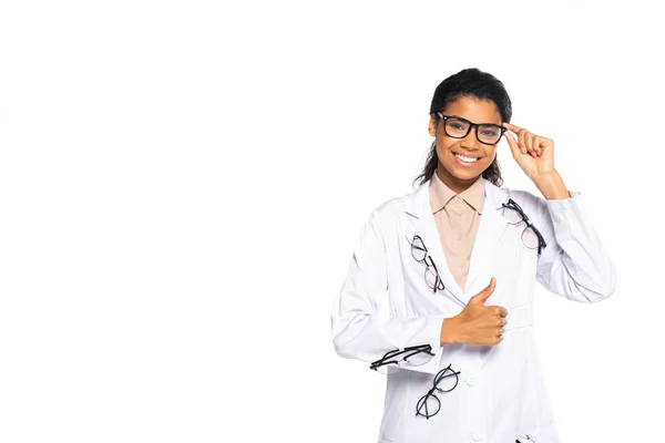 Oftalmologista afro-americano sorridente com óculos mostrando como sinal isolado em branco — Fotografia de Stock