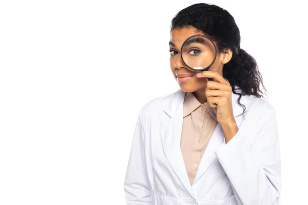 Young african american doctor holding magnifying glass isolated on white — Stock Photo