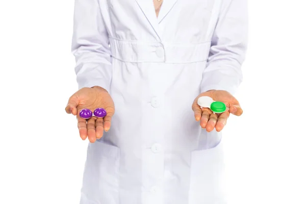 Обрізаний вид контейнерів з лінзами на руках афроамериканського лікаря ізольовано на білому — стокове фото