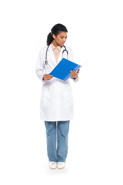 Full length of african american doctor holding paper folder on white background — Stock Photo