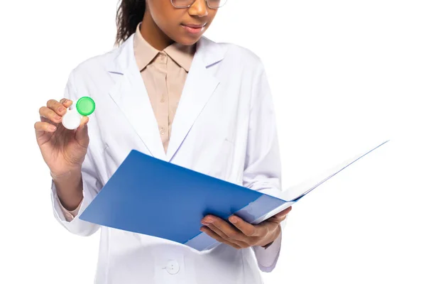 Cropped view of african american doctor holding paper folder and contact lenses isolated on white — Stock Photo