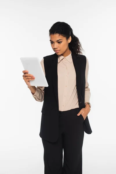 Молодая африканская американская бизнесвумен смотрит на цифровой планшет изолирован на белом — стоковое фото