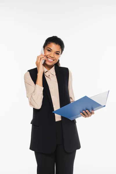 Junge afrikanisch-amerikanische Geschäftsfrau spricht auf Smartphone und hält Papiermappe isoliert auf weiß — Stockfoto