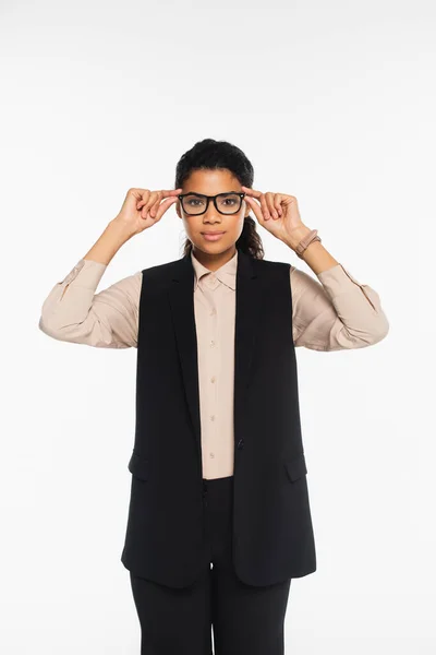 Young african american businesswoman holding eyeglasses while looking at camera isolated on white — Stock Photo