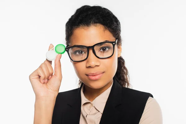 Retrato de empresária afro-americana em óculos segurando recipiente com lentes de contato isoladas em branco — Fotografia de Stock