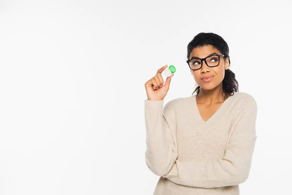 Pensive african american woman in eyeglasses holding contact lenses isolated on white — Stock Photo