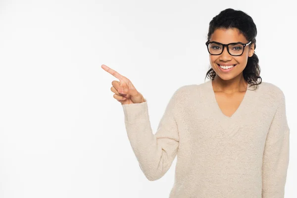 Mujer afroamericana feliz en gafas que señalan con el dedo aislado en blanco - foto de stock