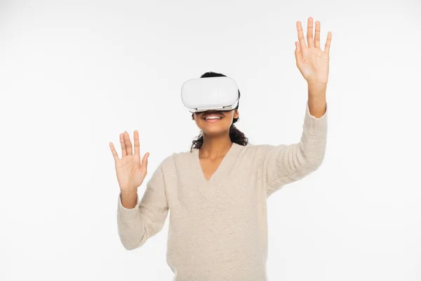 Smiling african american woman in sweater using vr headset isolated on white — Stock Photo