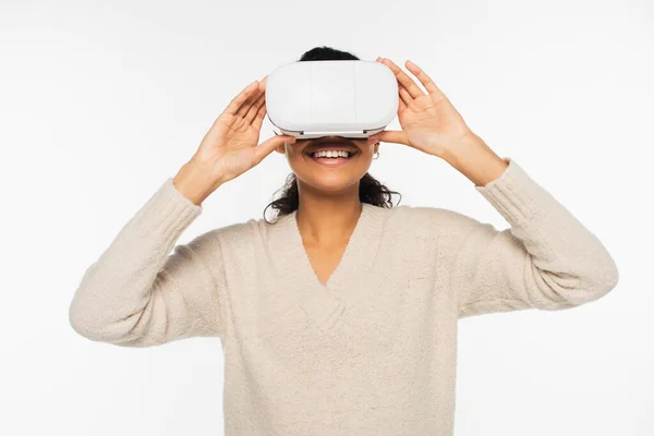 Mujer afroamericana joven usando auriculares de realidad virtual aislados en blanco - foto de stock