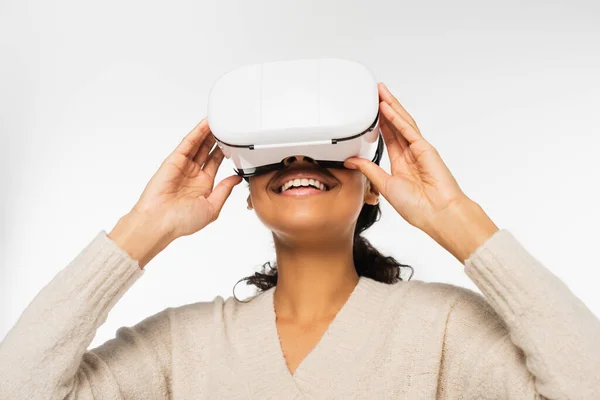 Femme afro-américaine souriante utilisant un casque de réalité virtuelle isolé sur blanc — Photo de stock