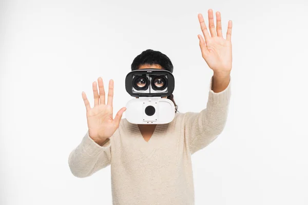 Mujer afroamericana haciendo gestos mientras usa auriculares vr aislados en blanco - foto de stock