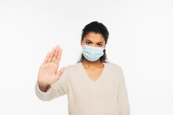 Femme afro-américaine sérieuse en masque médical montrant geste d'arrêt isolé sur blanc — Photo de stock