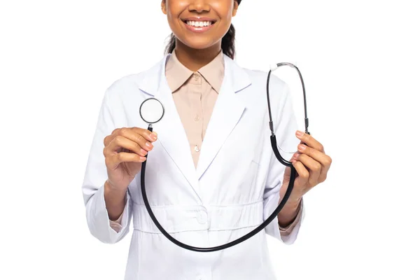 Vue recadrée du médecin afro-américain souriant tout en tenant stéthoscope isolé sur blanc — Photo de stock