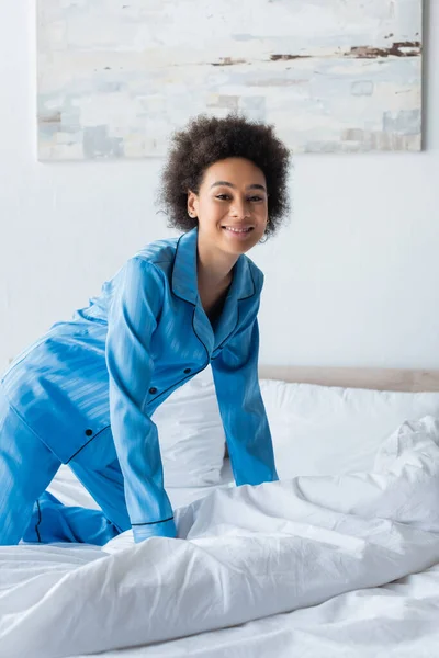 Довольная африканская американка в пижаме на кровати — стоковое фото