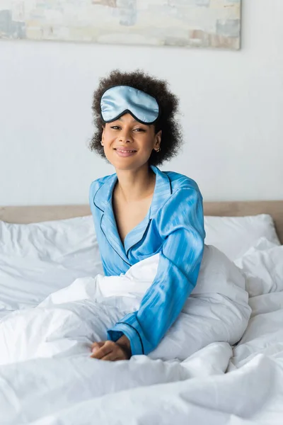 Sorridente donna afroamericana in pigiama e maschera addormentata — Foto stock