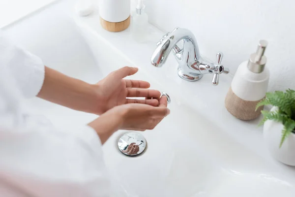 Vista de ángulo alto de la mujer afroamericana lavándose las manos en el baño - foto de stock