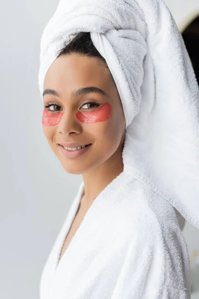 Happy african american woman with eye patches smiling in bathroom — Stock Photo