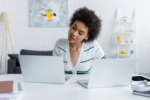 African american freelancer working from home near laptops on desk — Stock Photo