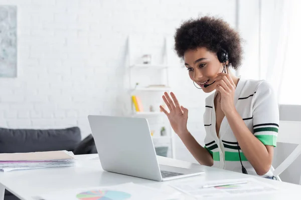 Afroamericano freelance in cuffia avendo videochiamata sul computer portatile a casa — Foto stock