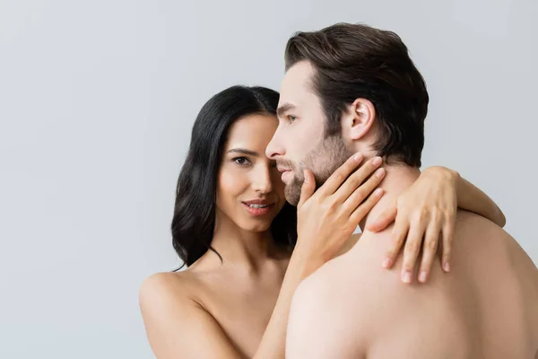 Nude woman looking at camera while embracing shirtless man isolated on grey — Stock Photo