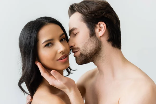 Shirtless man touching face of brunette woman looking at camera isolated on grey — Stock Photo