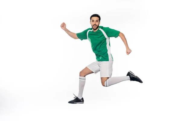 Feliz jovem jogador de futebol em uniforme pulando isolado no branco — Fotografia de Stock