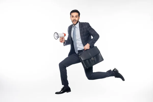 Бизнесмен в костюме прыгает с громкоговорителем и портфелем на белом — стоковое фото