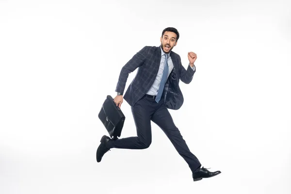Позитивний бізнесмен у костюмі, стрибає з портфелем на білому — стокове фото