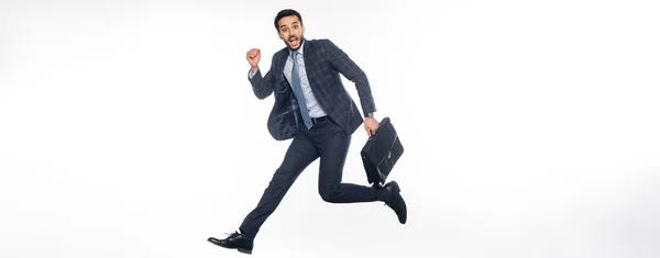 Positive businessman in suit jumping with briefcase on white, banner — Stock Photo