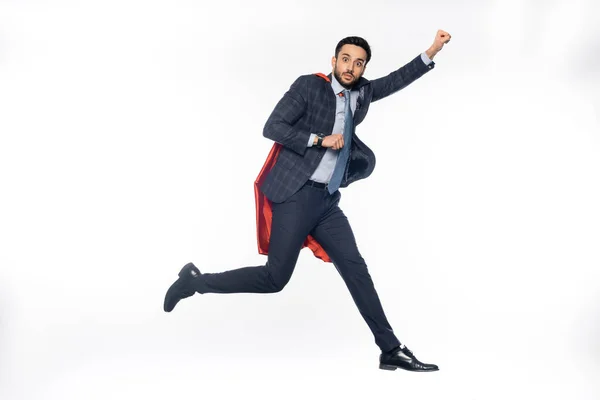 Geschäftsmann in Anzug und Superhelden-Umhang schwebt auf Weiß — Stockfoto