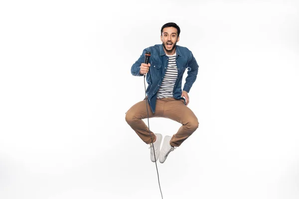 Glücklicher Mann schwebt, während er Mikrofon auf weiß hält — Stockfoto