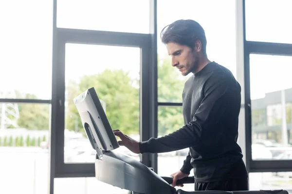 Side view of sportsman training on treadmill in gym — Foto stock