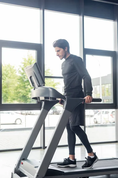 Brünette Sportlerin trainiert auf Laufband im Sportzentrum — Stockfoto