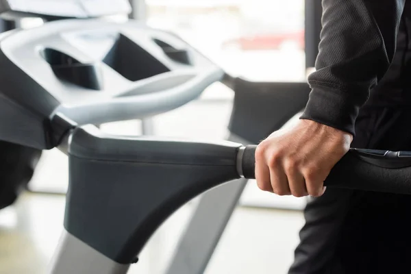 Cropped view of sportsman training on treadmill in gym — Stock Photo