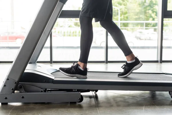 Cropped view of sportsman training on treadmill in sports center — Stock Photo