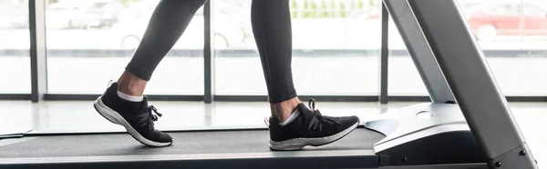 Vista recortada del deportista corriendo en la cinta de correr en el gimnasio, pancarta - foto de stock