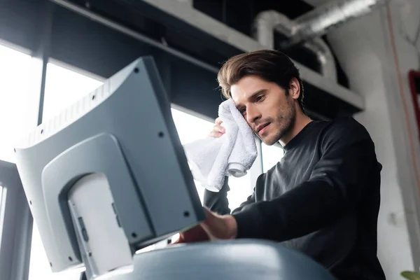 Low angle view of sportsman with towel training on treadmill in sports center — Stock Photo