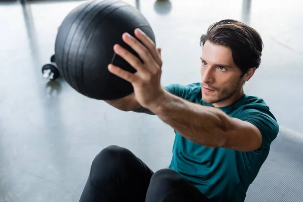 Sportsman training with blurred slam ball in sports center — Stockfoto