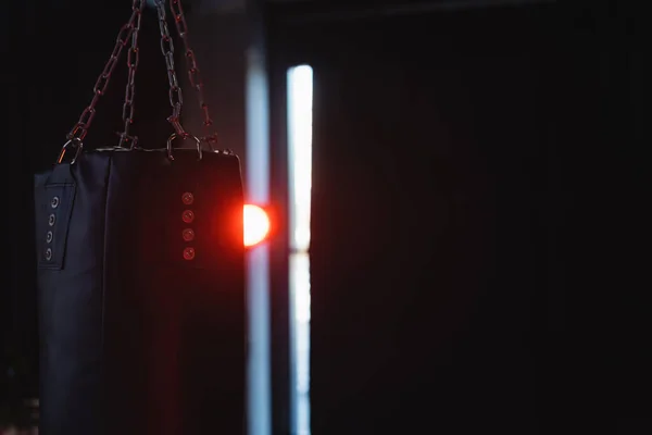 Saco de perfuração no fundo escuro com iluminação no ginásio — Fotografia de Stock