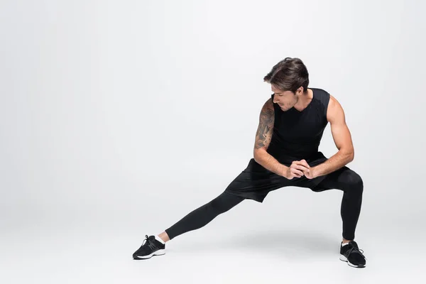 Entraînement sportif tatoué sur fond gris — Photo de stock